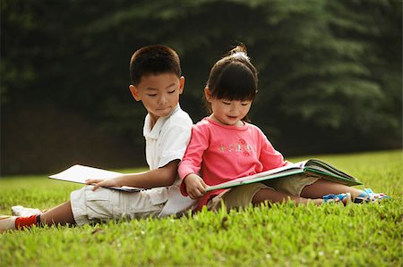 little boy and girl reading a book outdoors Stock Photo - Premium Royalty-Free, Code: 656-02879667