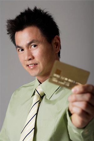 simsearch:656-02879575,k - man smiling behind gold credit card Fotografie stock - Premium Royalty-Free, Codice: 656-02879660