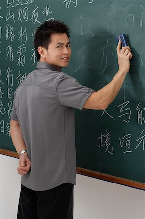 man erasing Chinese characters on chalk board Stock Photo - Premium Royalty-Free, Code: 656-02879672