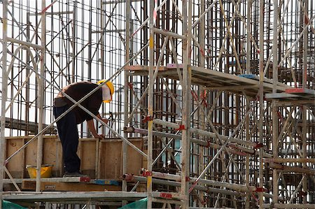 Construction worker in building frame. Stock Photo - Premium Royalty-Free, Code: 656-03076209