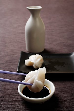 dimsum still life - chopstick dipping dim sum in soy sauce Stock Photo - Premium Royalty-Free, Code: 656-03076226