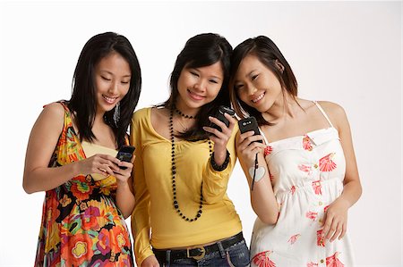Three women looking at hand phones. Stock Photo - Premium Royalty-Free, Code: 656-03076222