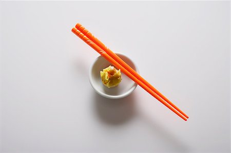 simsearch:656-04926513,k - dim sum dans un bol avec des baguettes oranges Photographie de stock - Premium Libres de Droits, Code: 656-03076311