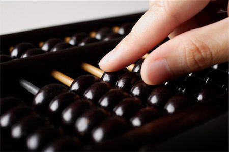 close up of hand touching abacus Foto de stock - Royalty Free Premium, Número: 656-03076312