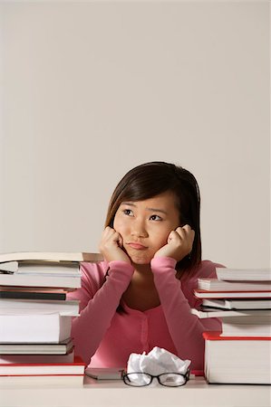 stressed student - Young woman sitting at desk with books looking sad. Foto de stock - Sin royalties Premium, Código: 656-03076313