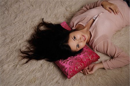 Chinese woman laying on rug Stock Photo - Premium Royalty-Free, Code: 656-03241065