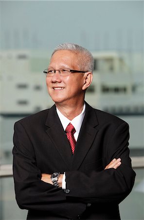 mature man wearing a suit smiling with arms crossed Stock Photo - Premium Royalty-Free, Code: 656-03519528