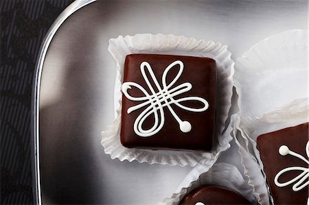 square - Chocolate petit fours with white icing (seen from above) Stock Photo - Premium Royalty-Free, Code: 659-06154006