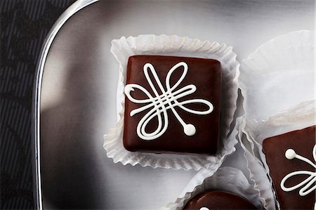 Chocolate petit fours with white icing (seen from above) Foto de stock - Sin royalties Premium, Código: 659-06154006