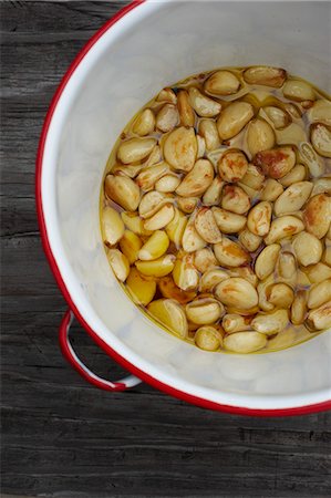 pickled - Roasted Garlic Cloves in Red Rimmed Pot Stock Photo - Premium Royalty-Free, Code: 659-06154030