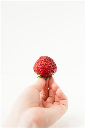 simple (sobre) - Main tenant une fraise ; Fond blanc Photographie de stock - Premium Libres de Droits, Code: 659-06154057