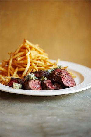 simsearch:659-06903721,k - Sliced Steak with Blue Cheese and French Fries on a White Plate Stock Photo - Premium Royalty-Free, Code: 659-06154246