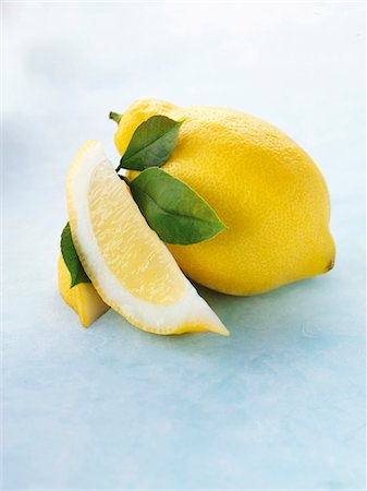 Whole lemon, lemon wedge and leaves Stock Photo - Premium Royalty-Free, Code: 659-06154265