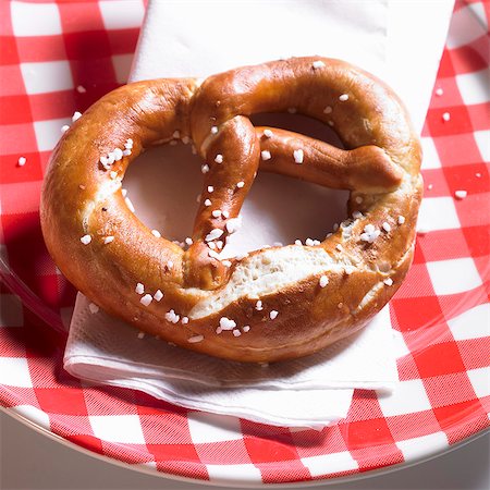pretzel - Lye pretzel on a plaid plate Foto de stock - Sin royalties Premium, Código: 659-06154320