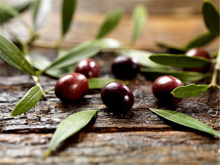 Black olives with leaves on a wooden surface Fotografie stock - Premium Royalty-Free, Codice: 659-06154888