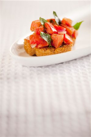 simsearch:659-06901339,k - Une Bruschetta sur une assiette blanche Photographie de stock - Premium Libres de Droits, Code: 659-06154898