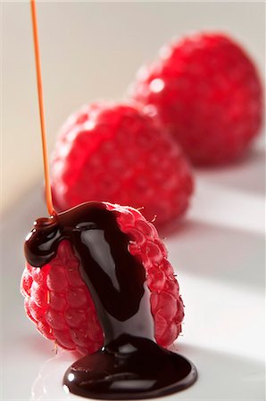 scorrere - Chocolate Sauce Pouring Over Fresh Raspberries Fotografie stock - Premium Royalty-Free, Codice: 659-06154912