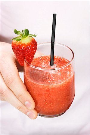 smoothie - A hand holding a glass of strawberry smoothie Stock Photo - Premium Royalty-Free, Code: 659-06155101