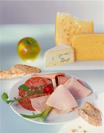 simsearch:659-03525156,k - Sliced meat platter with various cheeses in the background Foto de stock - Sin royalties Premium, Código: 659-06155262