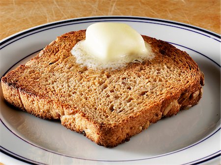 Pat of Butter Melting on a Piece of Whole Grain Toast Foto de stock - Sin royalties Premium, Código: 659-06155453