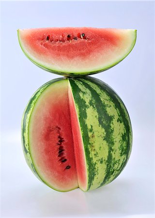 Ein Stück Wassermelone auf einer geschnittenen Wassermelone Stockbilder - Premium RF Lizenzfrei, Bildnummer: 659-06155791