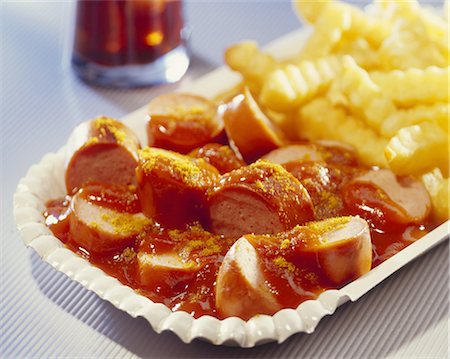 Curried sausage with chips on a paper plate Stock Photo - Premium Royalty-Free, Code: 659-06151069