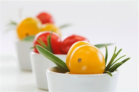 salva - Red and yellow cherry tomatoes, sage and rosemary Foto de stock - Royalty Free Premium, Número: 659-06151093