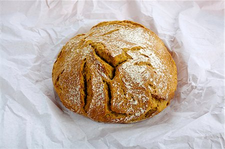 farmhouse bread - Country bread on a piece of paper Foto de stock - Sin royalties Premium, Código: 659-06151118