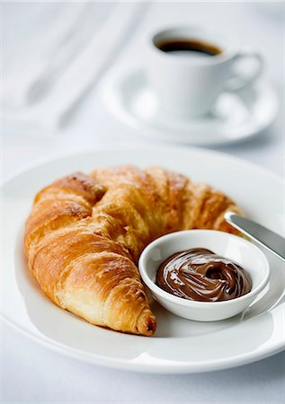 Croissant spread with chocolate and an espresso Foto de stock - Sin royalties Premium, Código: 659-06151124