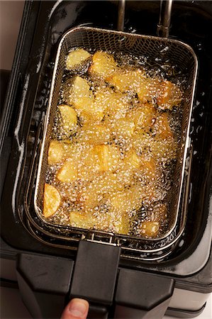 simsearch:659-07027704,k - Potatoes being fried in a deep fat fryer Foto de stock - Sin royalties Premium, Código: 659-06151174