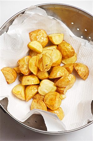 frito - Deep fried potatoes being dried on kitchen paper Foto de stock - Sin royalties Premium, Código: 659-06151177