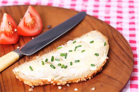 simsearch:659-06495132,k - Une tranche de pain tartiné de beurre et de la ciboulette sur plaque en bois Photographie de stock - Premium Libres de Droits, Code: 659-06151299