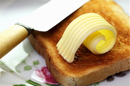 A slice of toast with a curl of butter Foto de stock - Sin royalties Premium, Código: 659-06151301