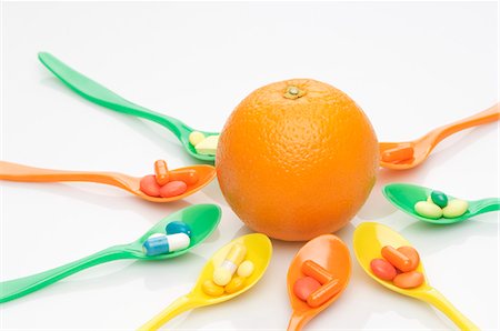 Cuillères avec des comprimés de vitamines autour d'une orange Photographie de stock - Premium Libres de Droits, Code: 659-06151406