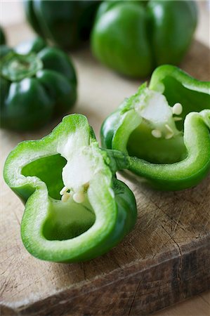 sweet pepper - Green peppers, whole and halved, on a chopping board Stock Photo - Premium Royalty-Free, Code: 659-06151562