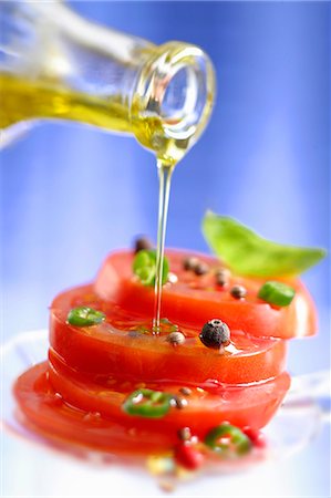 Spiced tomatoes being drizzled with olive oil Stock Photo - Premium Royalty-Free, Code: 659-06151611