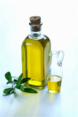 A bottle and a carafe of olive oil with an olive sprig Stock Photo - Premium Royalty-Free, Code: 659-06151668