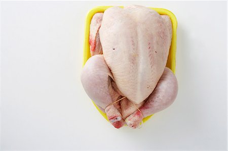 A ready-to-roast chicken, seen from above Stock Photo - Premium Royalty-Free, Code: 659-06151692
