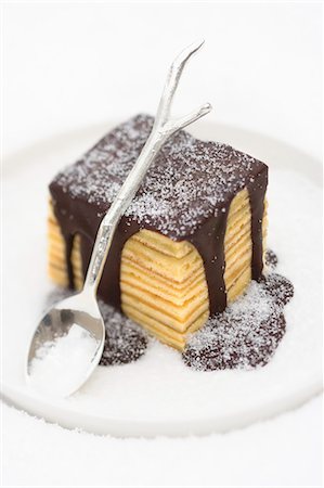 simsearch:659-06188290,k - Baumkuchen (German layer cake) with chocolate sauce and sugar Stock Photo - Premium Royalty-Free, Code: 659-06151700