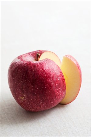 Une pomme rouge avec une tranche supprimée Photographie de stock - Premium Libres de Droits, Code: 659-06151735