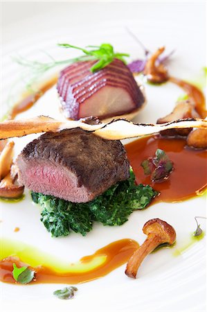 fillet beef recipes - Beef fillet on a bed of spinach served with vegetables and gravy Stock Photo - Premium Royalty-Free, Code: 659-06151871