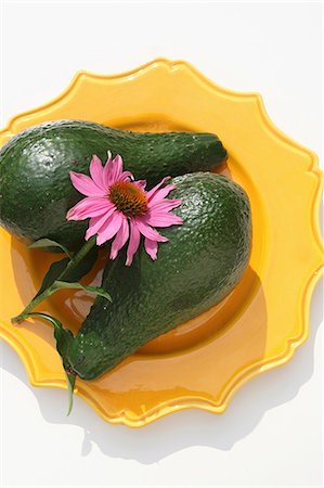 echinacea - Two avocados with an echinacea flower on a yellow plate Fotografie stock - Premium Royalty-Free, Codice: 659-06151910