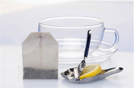 A lemon press with a slice of lemon, a tea bag and a tea cup Foto de stock - Sin royalties Premium, Código: 659-06151960