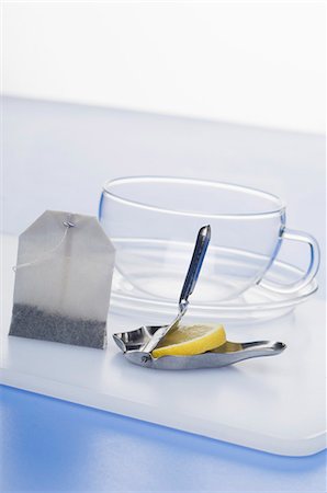 presse-agrumes - Une presse citron avec une tranche de citron, un sachet de thé et une tasse de thé Photographie de stock - Premium Libres de Droits, Code: 659-06151961