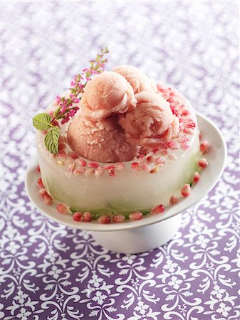 Pomegranate Sorbet in an Ice "Bowl" with a Sprig of Pink Flowers Stock Photo - Premium Royalty-Free, Code: 659-06151994