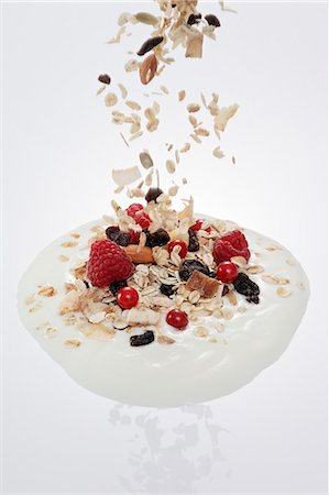 simsearch:659-03537241,k - Fruit muesli falling into a dollop of yogurt Foto de stock - Royalty Free Premium, Número: 659-06152072