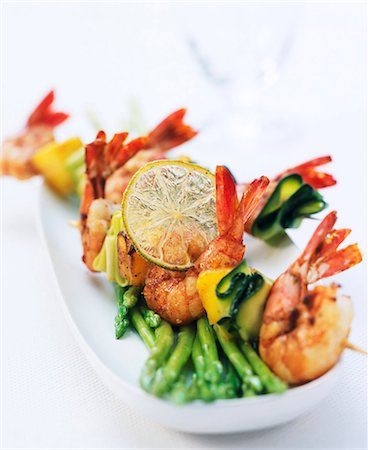 Brochette de scampi avec courgettes sur asperges vertes Photographie de stock - Premium Libres de Droits, Code: 659-06152114