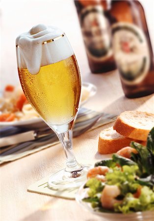 A glass of beer, salad and beer bottles Stock Photo - Premium Royalty-Free, Code: 659-06152110