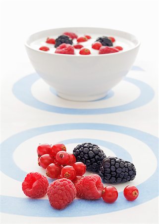 simsearch:659-07027527,k - Fresh berries with a bowl of yogurt and berries in the background Stock Photo - Premium Royalty-Free, Code: 659-06152135