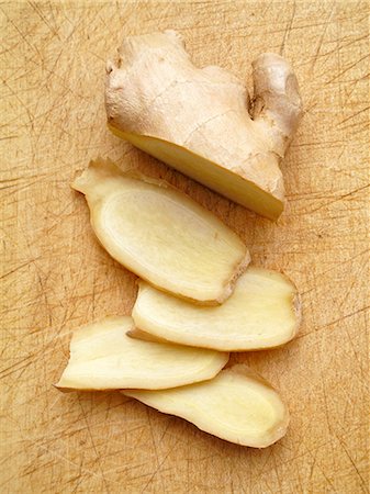 Fresh ginger, sliced, on a chopping board Stock Photo - Premium Royalty-Free, Code: 659-06152131